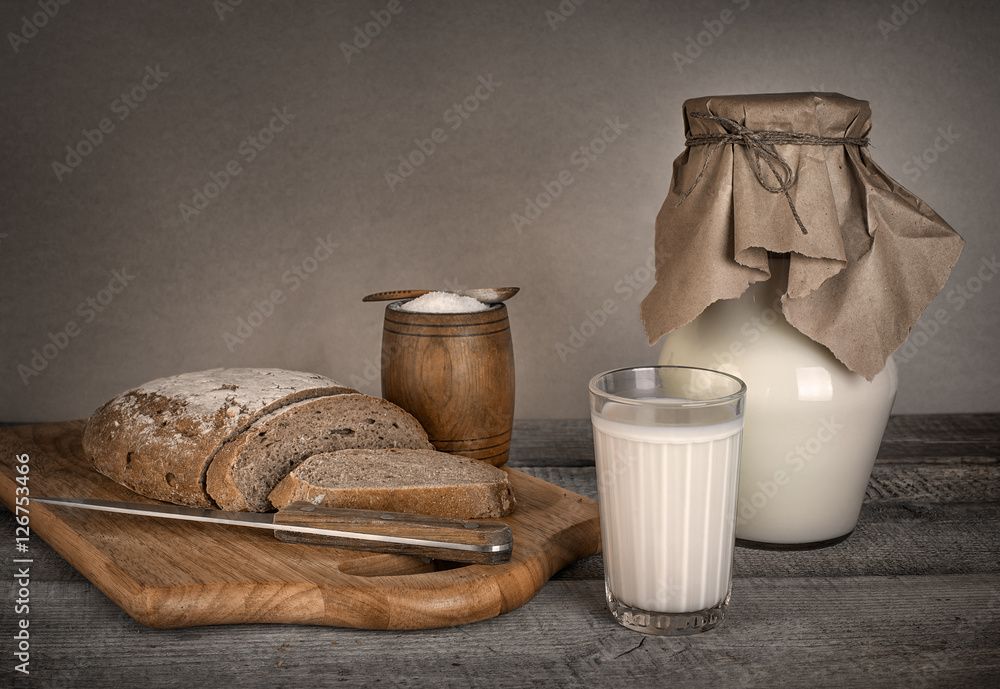 glass of milk and fresh homemade bread with solt on wooden table