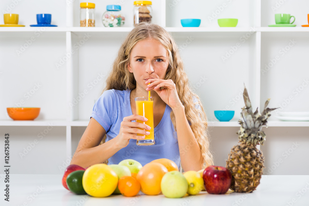 Beautiful girl enjoys drinking orange juice at her home.
Beautiful girl enjoys drinking orange juice at her home.