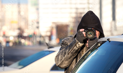 A paparazzi secretly takes photos
 photo