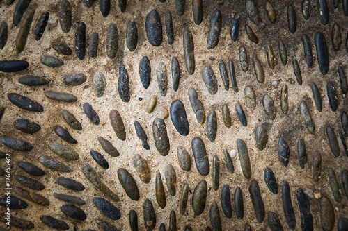 Round stones in the ground, Cobblestones in concrete background.