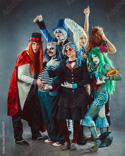 The troupe of mad circus actors on the grey background.