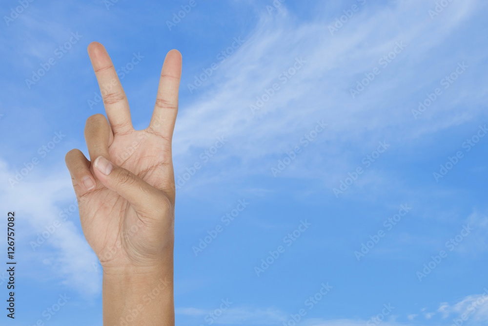 symbol of victory by hand with blue sky background symbol of victory by hand with blue sky background