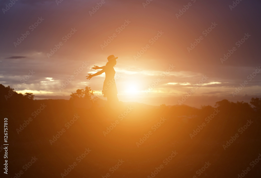 Silhouette of woman praying over beautiful sky background