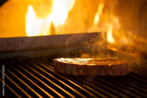 cooking the meat on the grill in the fireplace in the restaurant