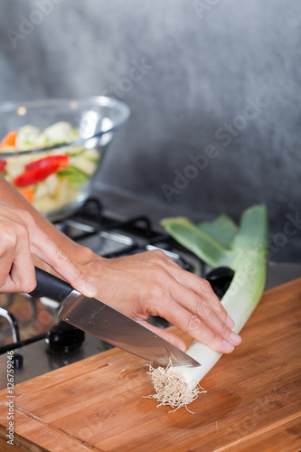 couper un poireau sur une planche dans une cuisine
