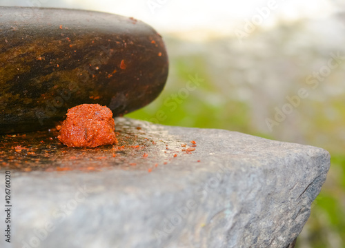 Traditional Sri Lankan way of grinding spices with the grinding stone. Before the electric blenders, the spices were painstakingly ground manually in all houses in Sri Lanka with the grinding stone photo