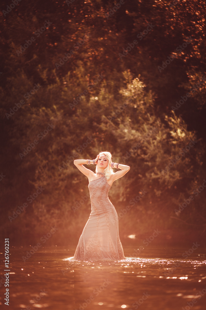 Hübsche junge blonde Frau mit Abendkleid im Wasser Hübsche junge blonde Frau mit Abendkleid im Wasser