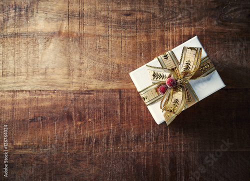 Christmas Present with Gold Ribbon on Rustic Wooden Background
