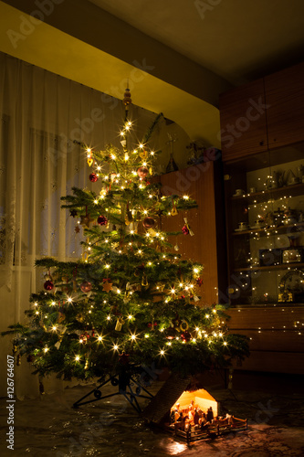 Nativity scene decoration under lighted Christmas tree