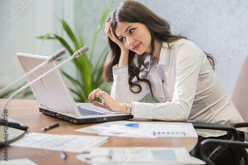 young woman businessman works behind laptop