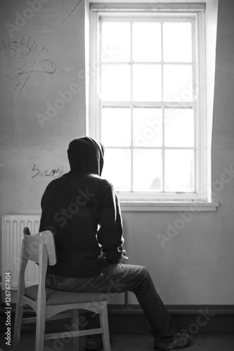 Lonely man looking out asylum window