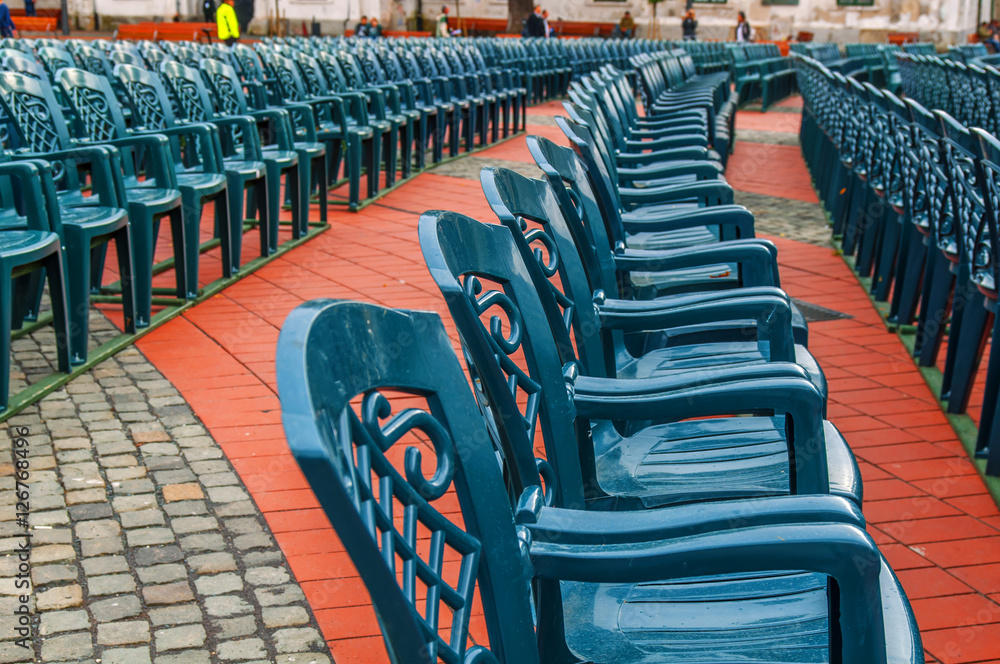 Fototapeta premium Stack of green plastic chair in the city square