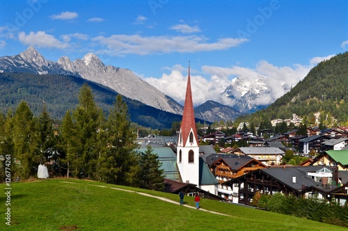 Aussicht über die Hausdächer der Gemeinde Seefeld, der Olympiaregion im Tirol, mit Blick auf die Kirche und die Tiroler Berge, Österreich photo
