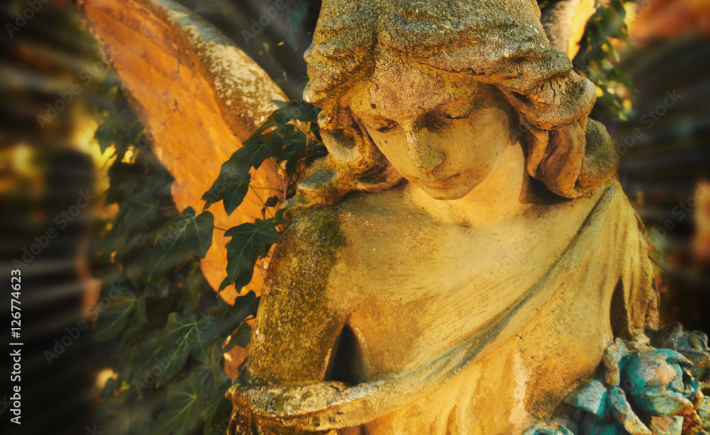 Fototapeta premium Majestic view of statue of golden angel illuminated by sunlight