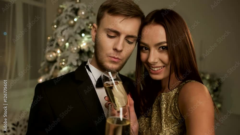 Happy smiling couple holding two glasses of champagne and celebrating New year day. Happy smiling couple holding two glasses of champagne and celebrating New year day.