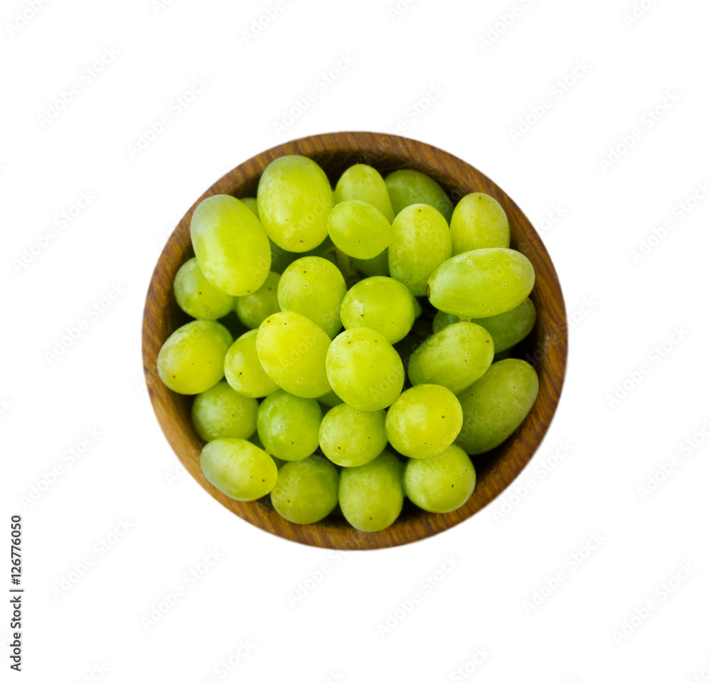 Grapes in a wooden bowl isolated on white background. Green grapes Kish Mish. Top view. Grapes in a wooden bowl isolated on white background. Green grapes Kish Mish. Top view.