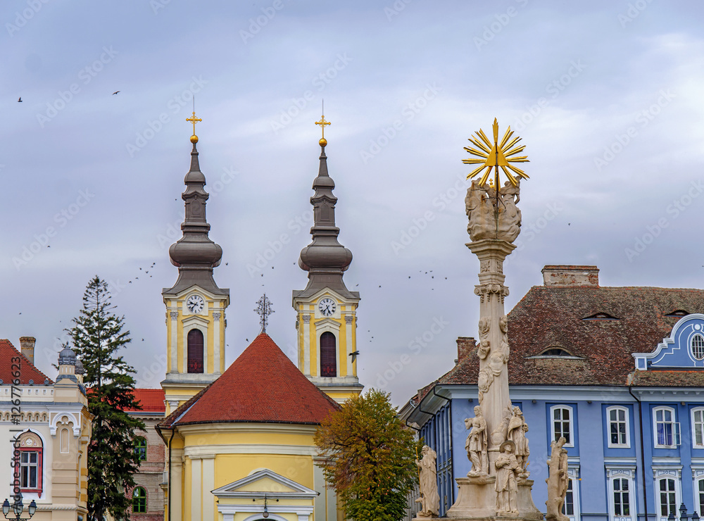 Obraz premium TIMISOARA, ROMANIA - 15 OCTOBER, 2016 Detail of the Holy Trinity Statue at Union square and Serbian Ortodox Church