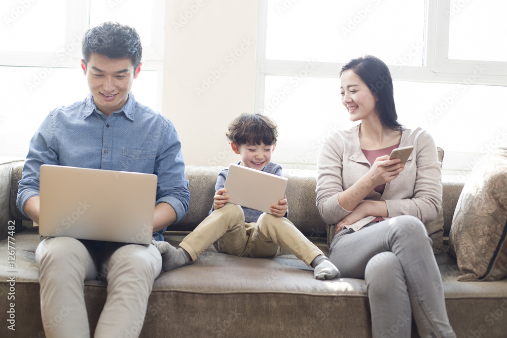 Happy young family using laptop and digital tablet Happy young family using laptop and digital tablet
