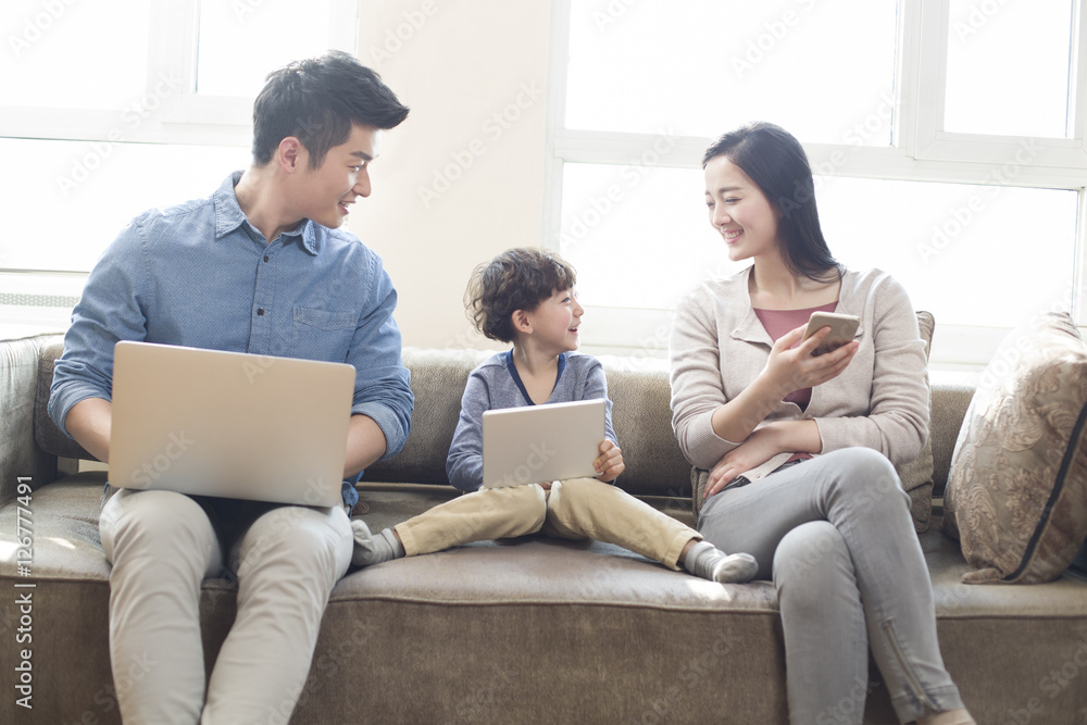 Happy young family using laptop and digital tablet Happy young family using laptop and digital tablet