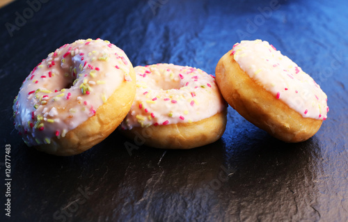 Colorful donuts on stone table