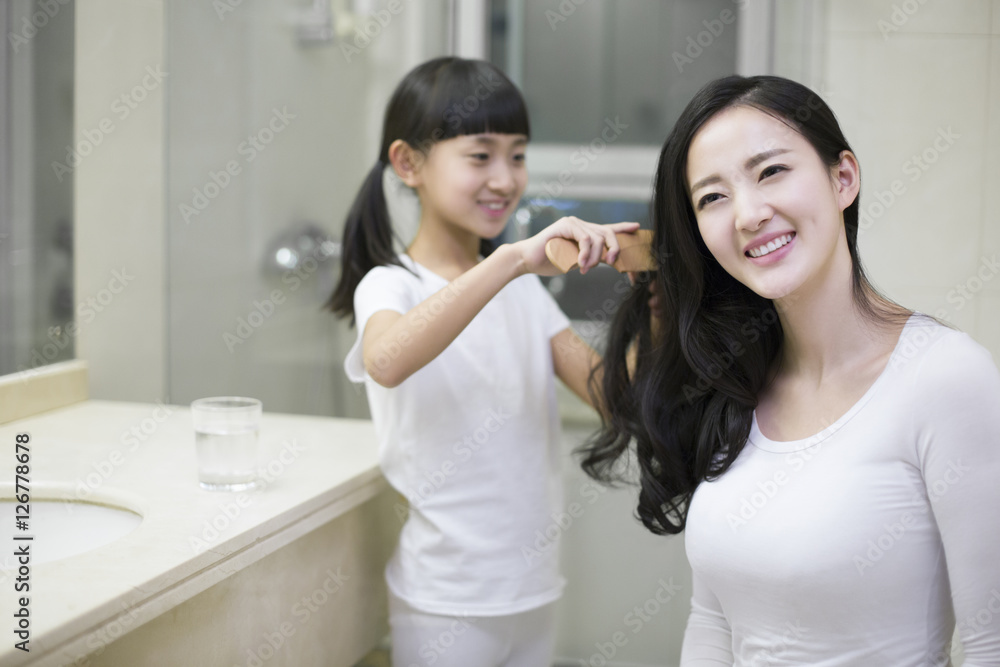 Little girl combing mom's hair Little girl combing mom's hair