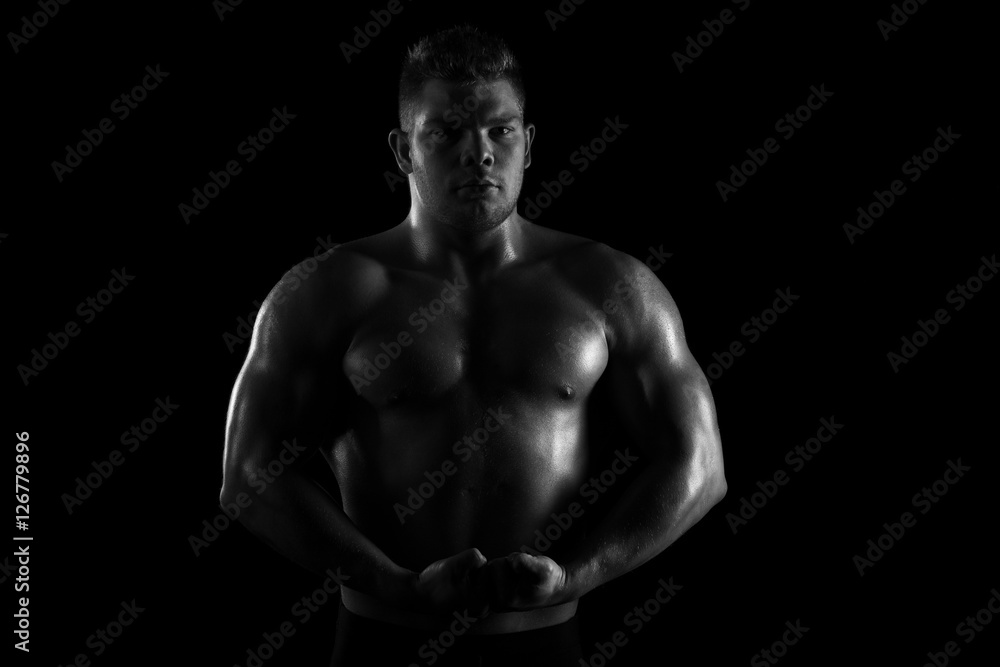 Fototapeta premium Strong young man showing his muscles and exercise 