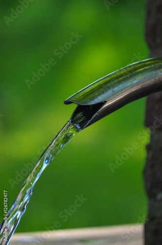 Close up of running water from a metal tap