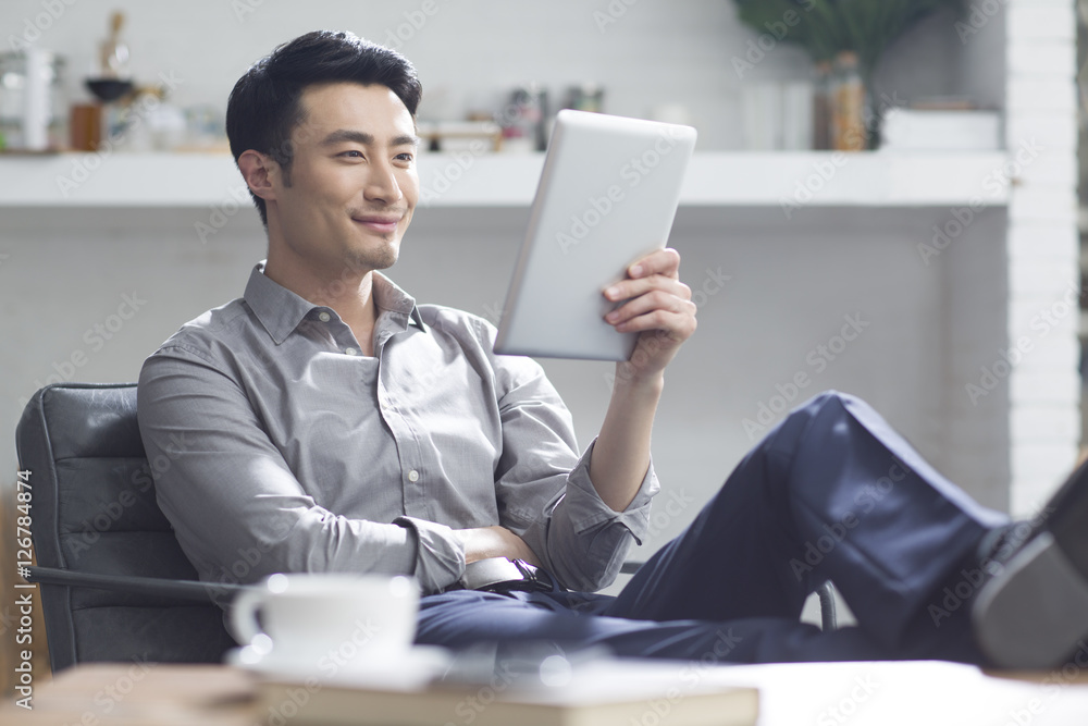Young man using digital tablet in office Young man using digital tablet in office