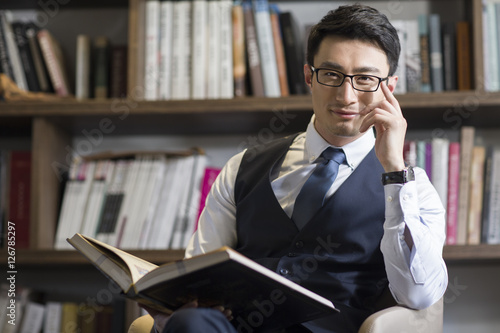 Fotografía Young businessman reading book in his study