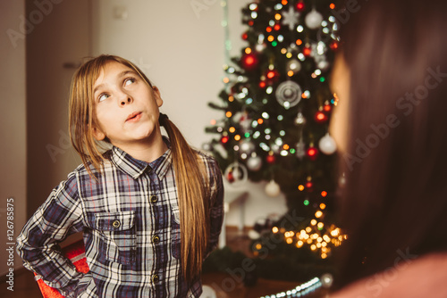 Girl holding christmas gift behind the back