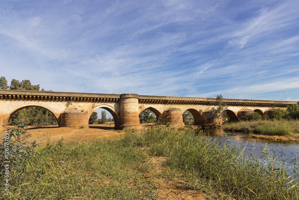 Landscape of old Roman Bridge with reflections in Tinto River, Niebla, Huelva, Andalusia, Spain