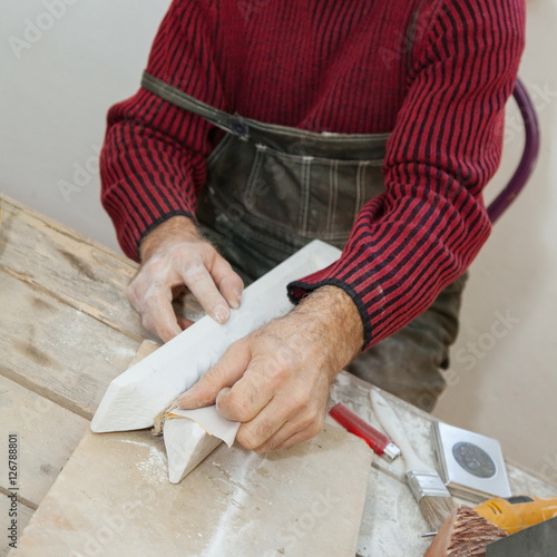 fine hand sanding a piece of marble with sandpaper