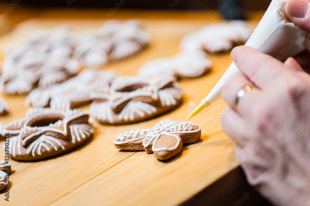 Obraz premium Decorating the traditional Christmas gingerbread cookies