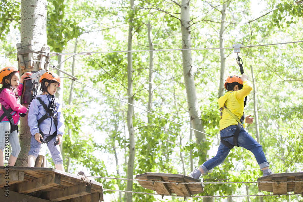 Happy children playing in tree top adventure park Happy children playing in tree top adventure park