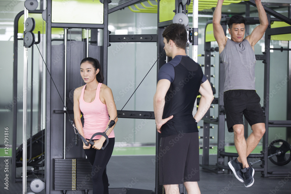Young woman working with trainer at gym Young woman working with trainer at gym