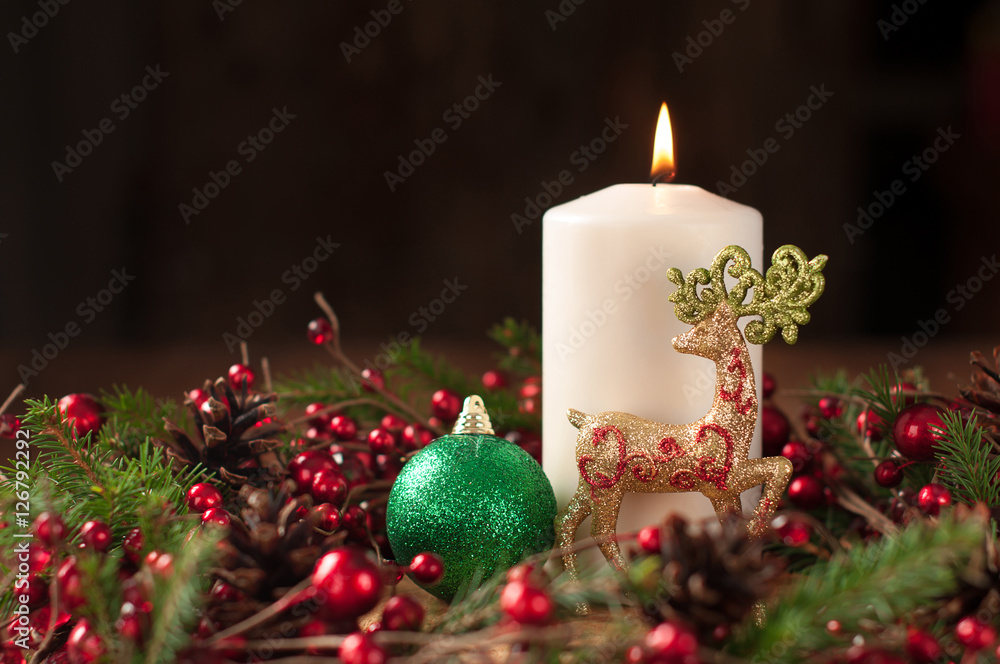 Christmas wreath with white candle, reindeer and ball dark background