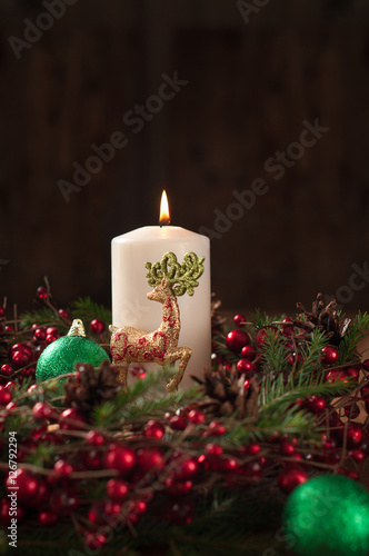 Christmas wreath with white candle  reindeer and ball dark background