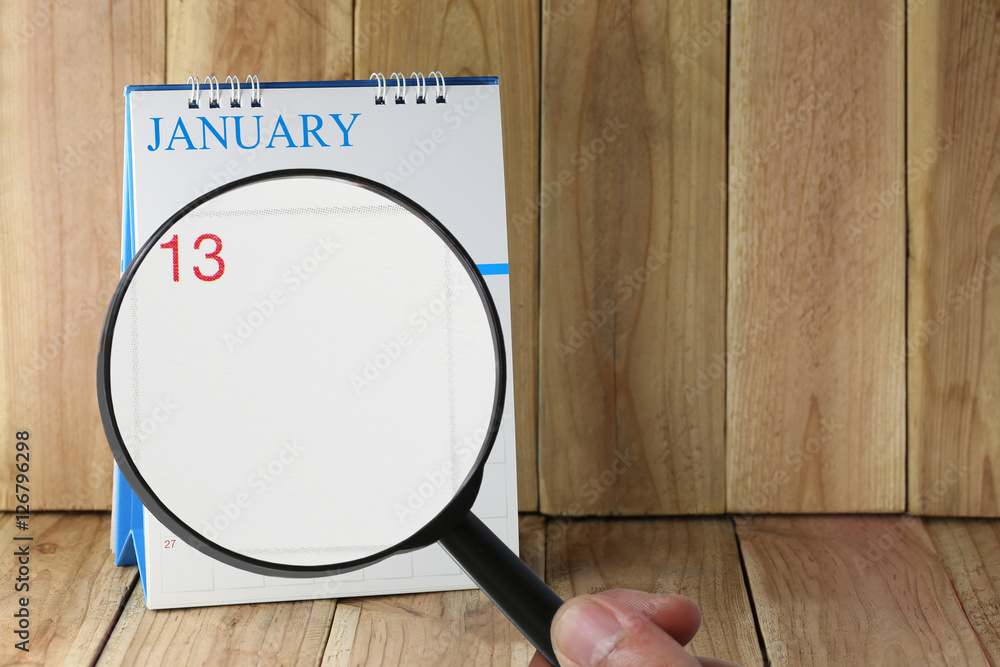 Magnifying glass in hand on calendar you can look Thirteen day o Magnifying glass in hand on calendar you can look Thirteen day o