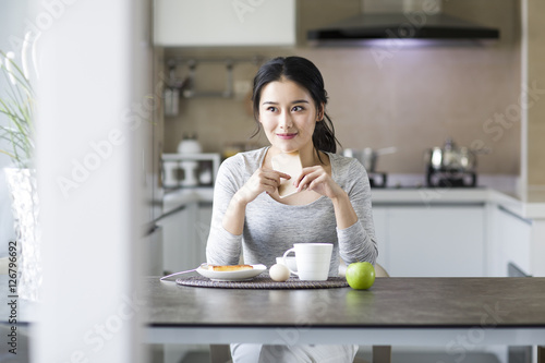 Young woman eating breakfast at home