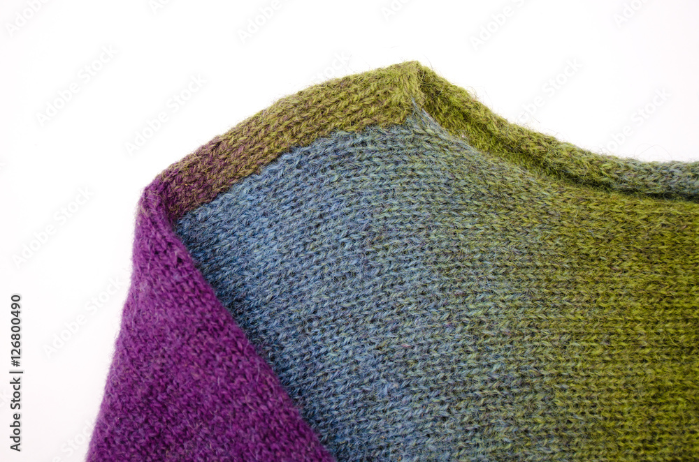 Fototapeta premium Part of handknitted sweater colored wool yarn on white background