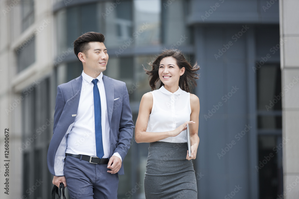 Confident business people talking and walking outdoors Confident business people talking and walking outdoors