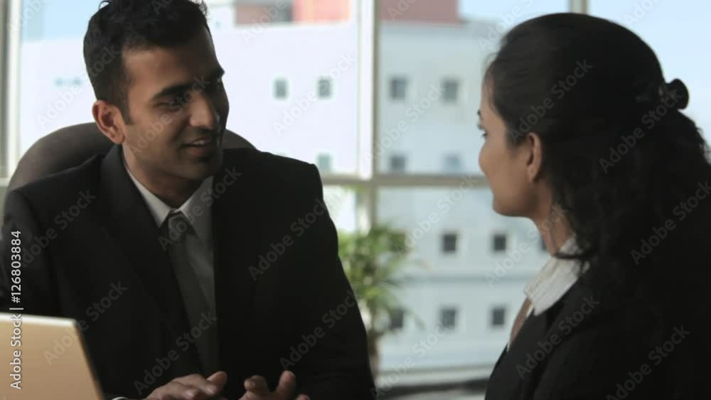 MS PAN Business couple sitting and talking in office MS PAN Business couple sitting and talking in office