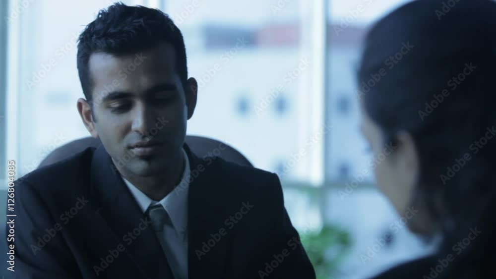 CU SELECTIVE FOCUS PAN Business couple sitting and talking in office CU SELECTIVE FOCUS PAN Business couple sitting and talking in office