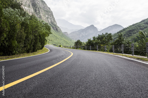 View of empty road amidst mountains against sky