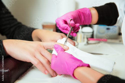 Manicure specialist care by finger nail.