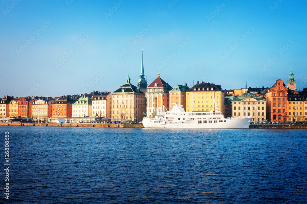 waterfront architecture of old town Gamla Stan in Stockholm with ship, Sweden, toned