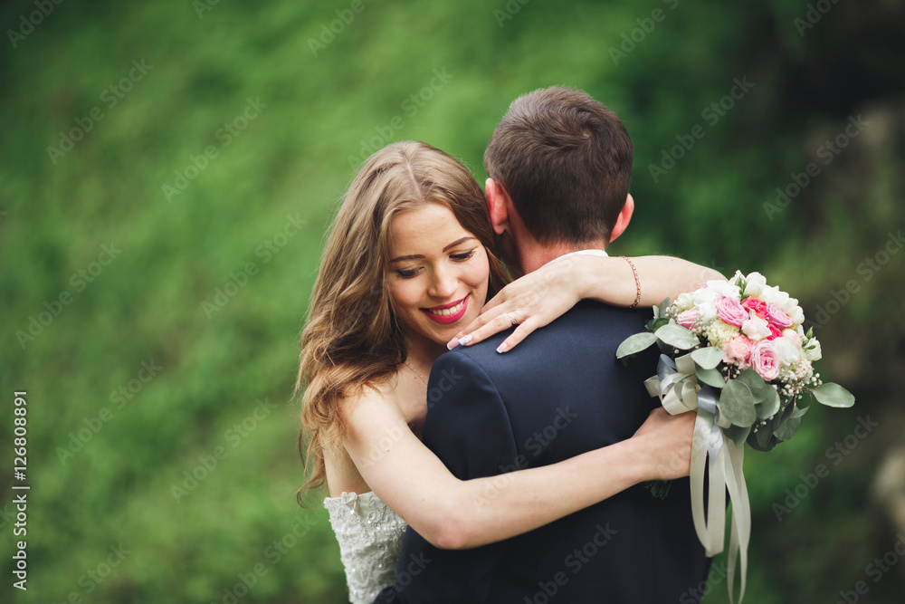 Happy wedding couple hugging and smiling each other on the background gorgeous plants in castle Happy wedding couple hugging and smiling each other on the background gorgeous plants in castle