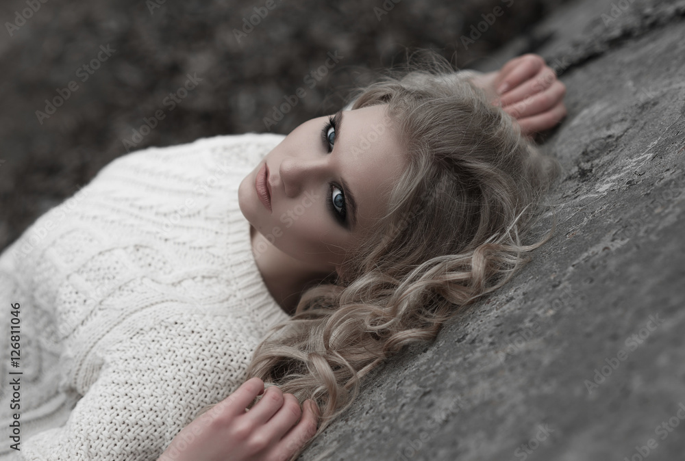 Close up of beautiful young blonde woman with blue eyes in white pullover. .Winter, spring, outdoor portrait. Close up of beautiful young blonde woman with blue eyes in white pullover. .Winter, spring, outdoor portrait.