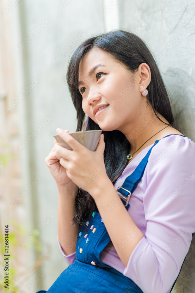 Asian cute women holding coffee cup on art wall Asian cute women holding coffee cup on art wall