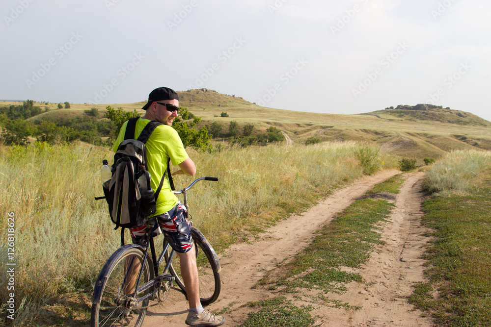 Man on the old bike is traveling across the steppe. Man on the old bike is traveling across the steppe.